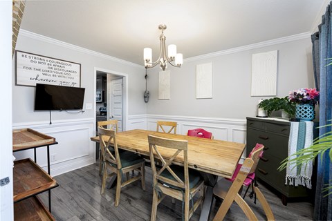 A dining room with a wooden table and chairs.
