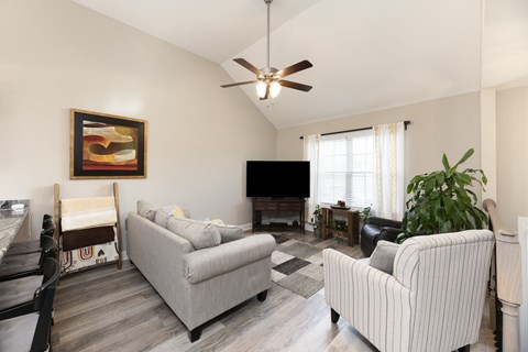 A living room with a striped couch and a television.
