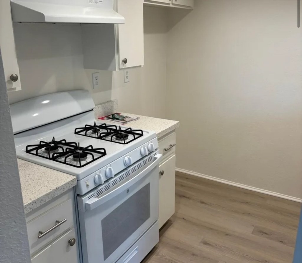 A white gas stove with a white oven in a kitchen.