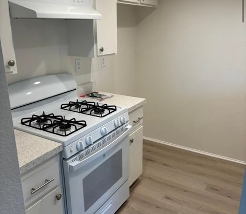 A white gas stove with a white oven in a kitchen.