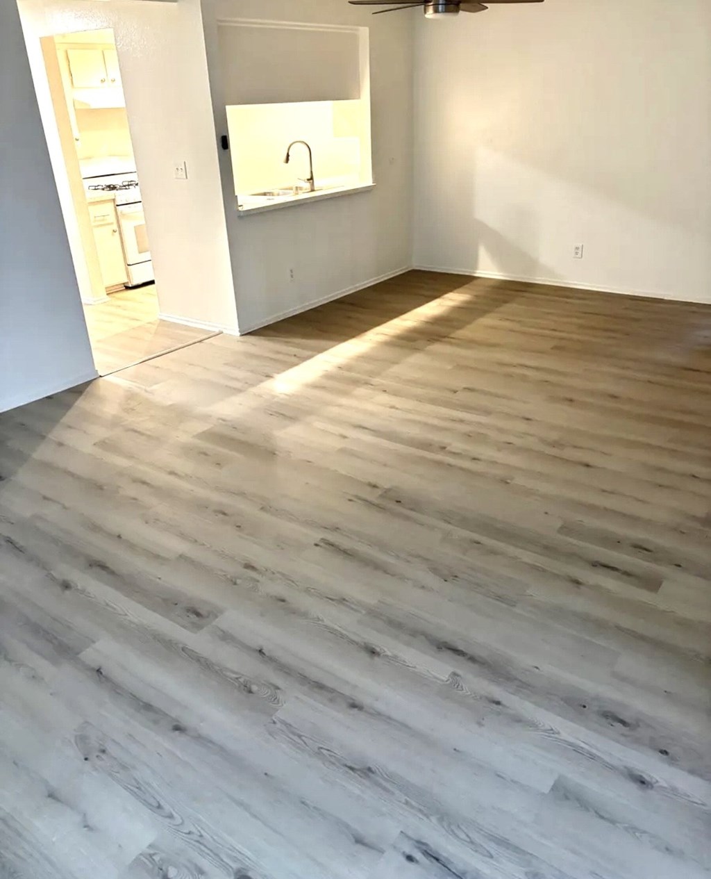 A room with a wooden floor and a mirror on the wall.