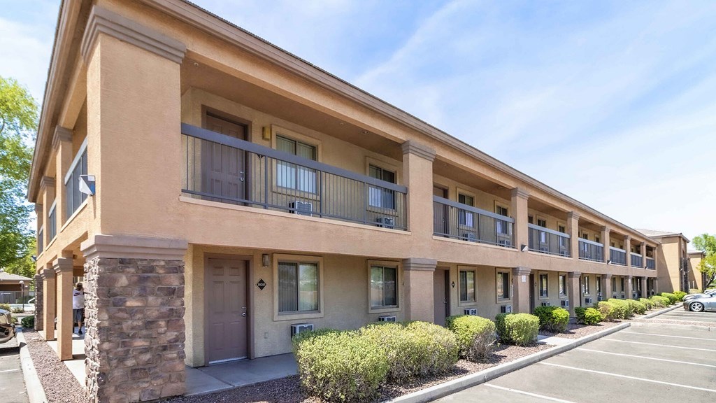 A row of apartment buildings with balconies and doors.