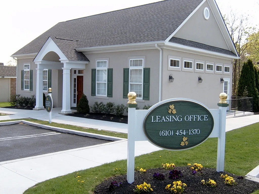 A leasing office building with a sign in front.