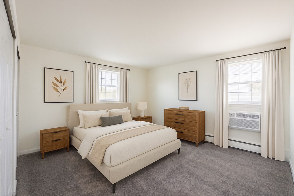 A bedroom with a large bed, nightstand, and window.