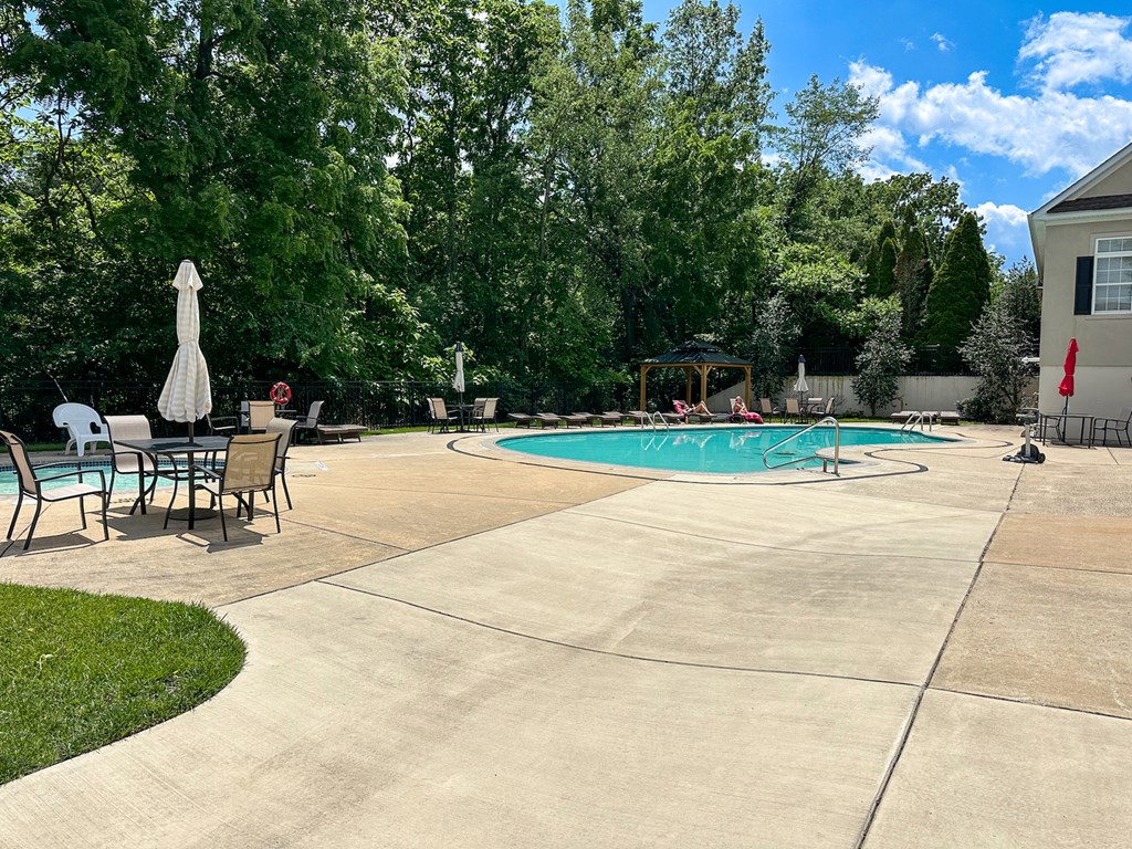 A backyard with a pool and patio furniture.