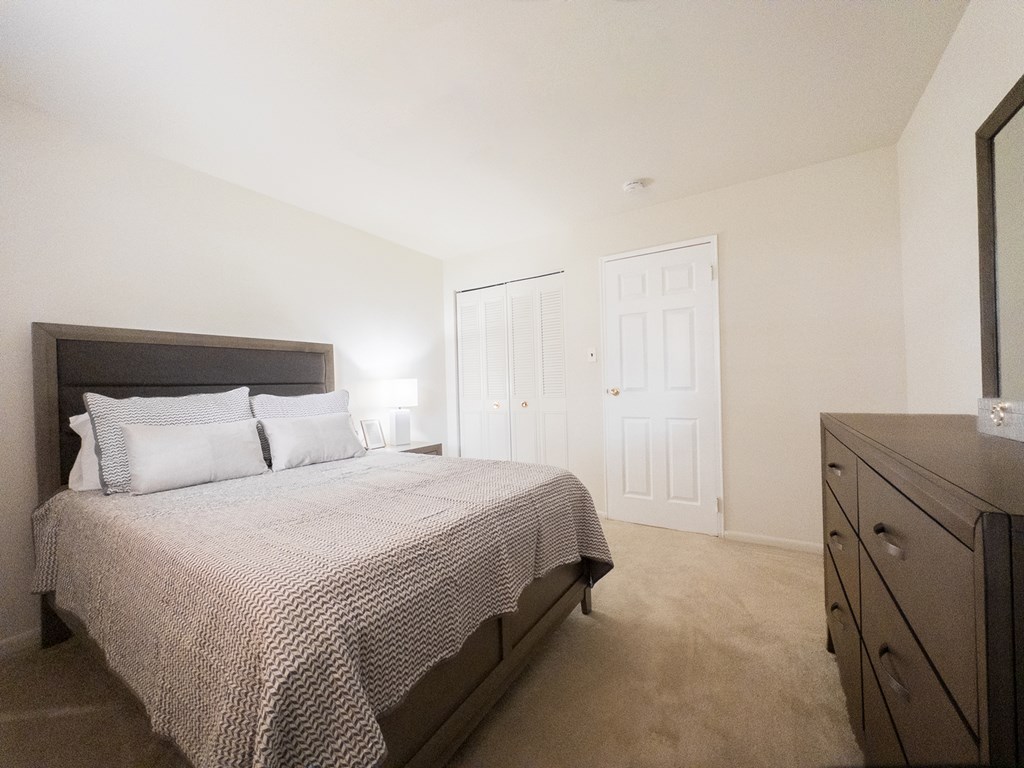 A parking lot in front of a building with a green lawn.