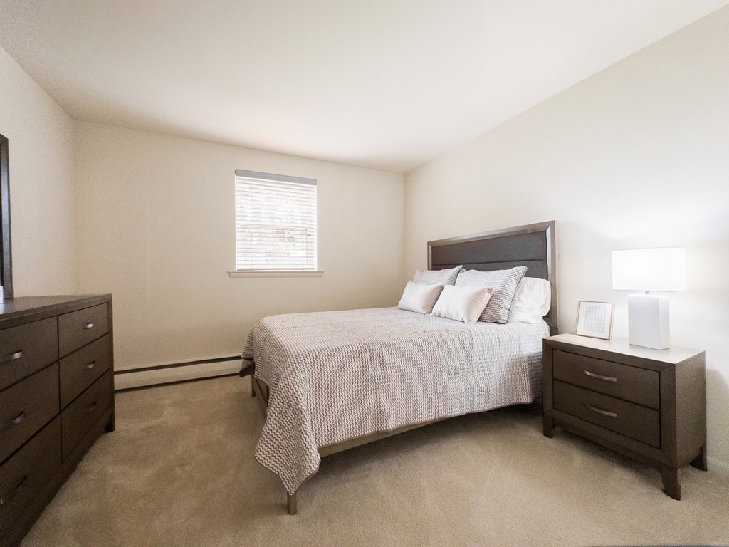 A bathroom with a toilet, sink, and towels.