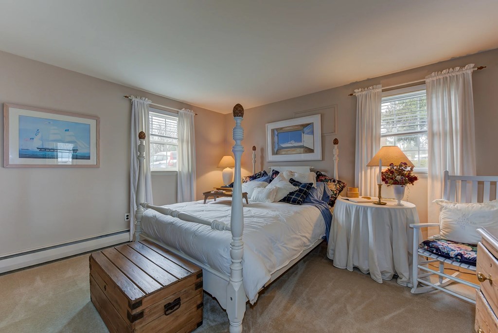 A bedroom with a large bed and a wooden crate on the floor.