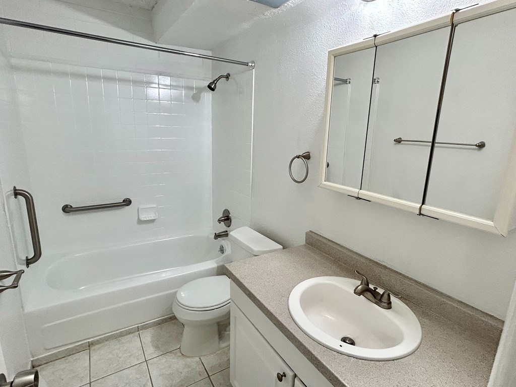 A white bathroom with a toilet, sink, and bathtub.