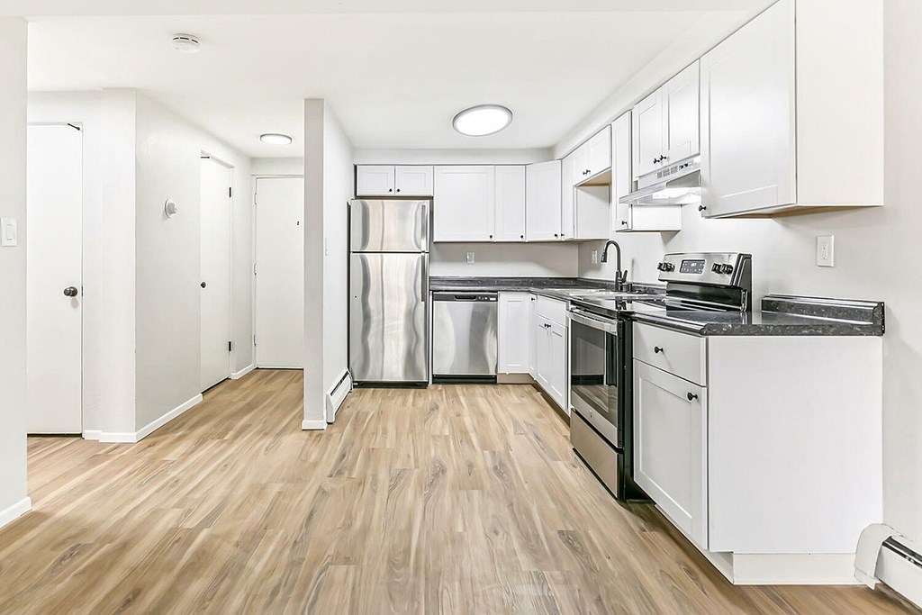 A kitchen with white cabinets and stainless steel appliances.