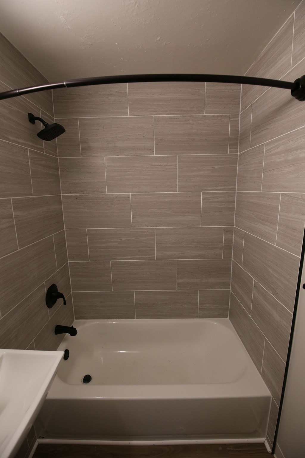A white bathtub with a shower head and faucet.