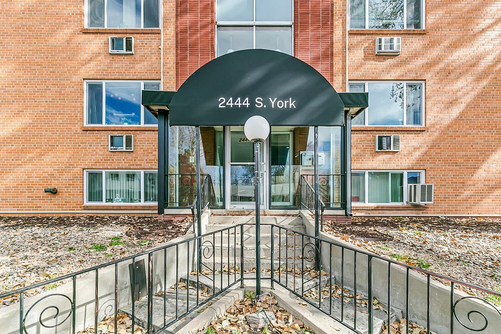 The entrance to a building with a black arch and the number 2444 on it.