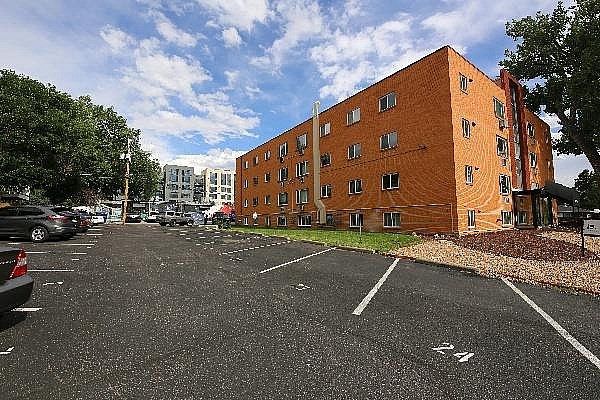 A parking lot with a red brick building in the background.