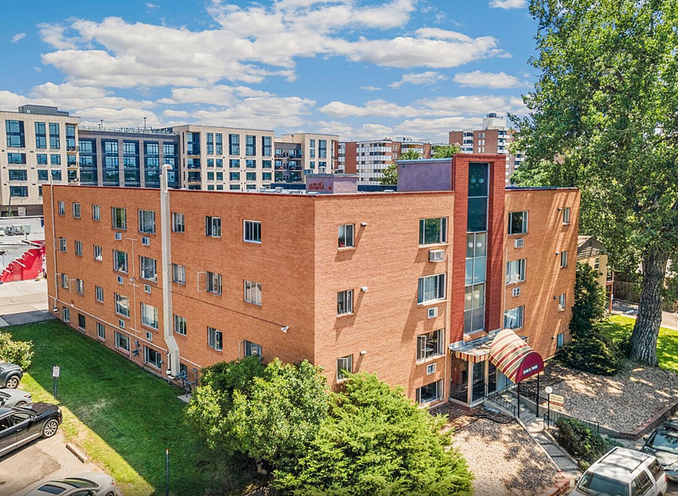 A red brick building with a green lawn in front.