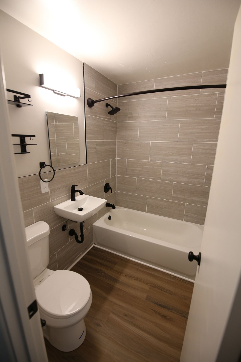 A white toilet is next to a white sink in a small bathroom.