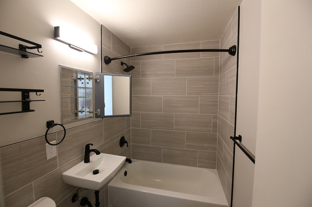 A bathroom with a white sink and a white bathtub.