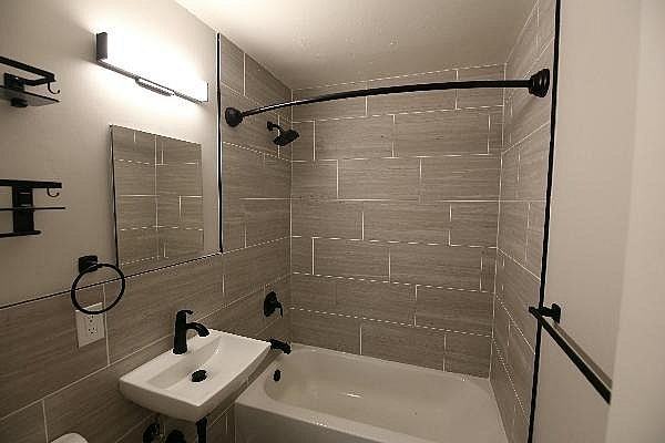 A bathroom with a white sink and a white tub.