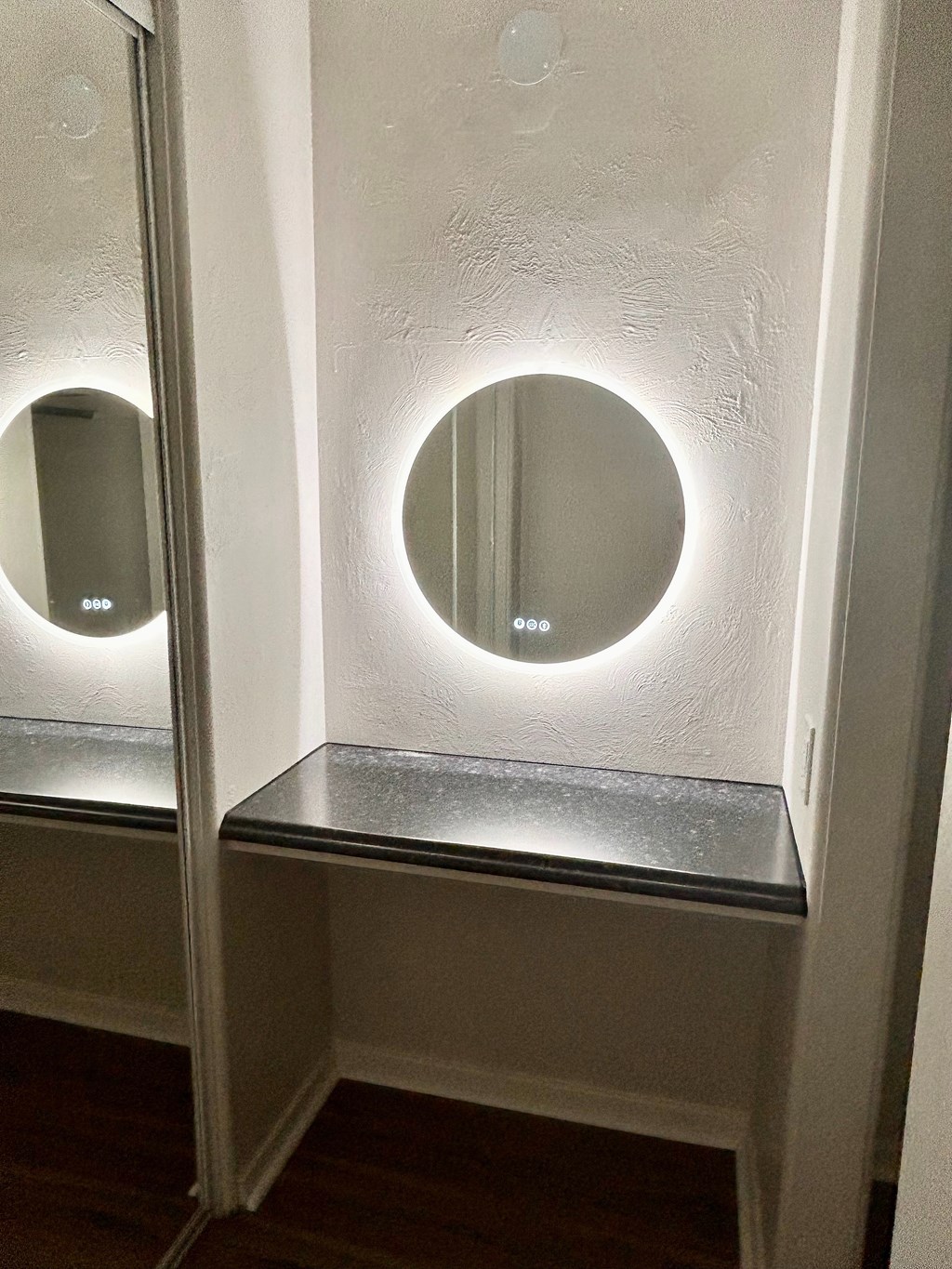 A bathroom with a mirror and a light on the wall.