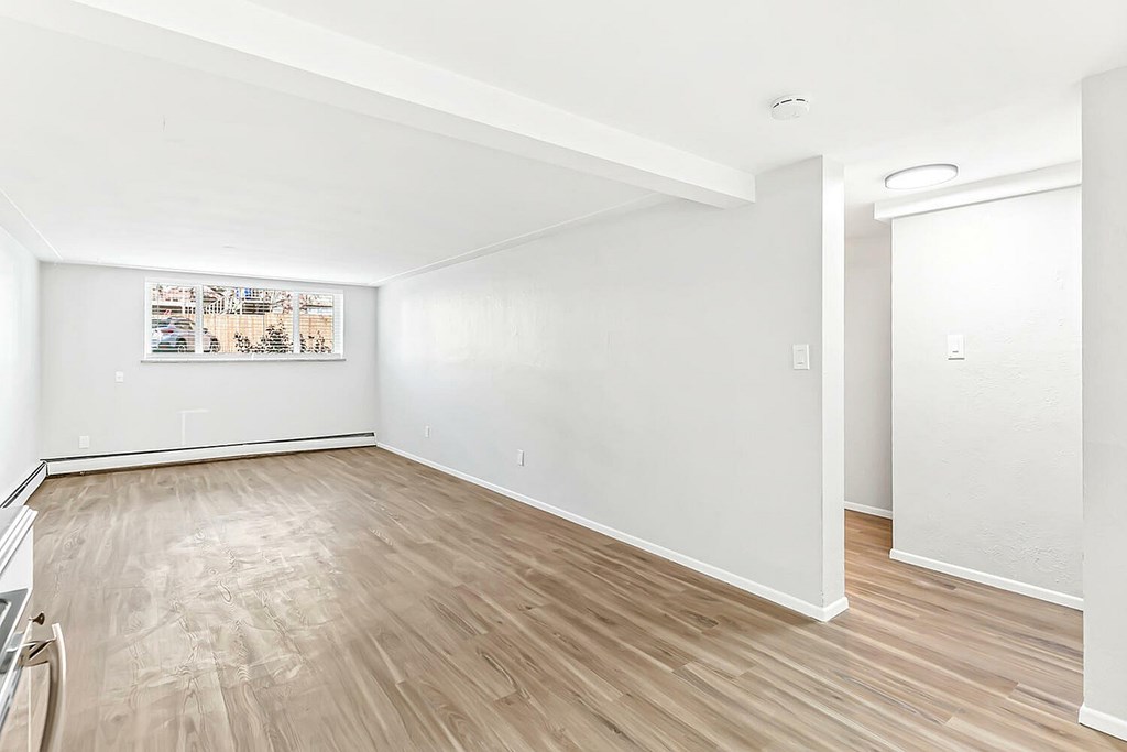 A room with wooden flooring and white walls.
