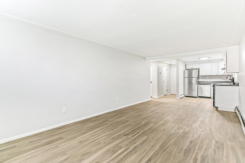 A kitchen area with a refrigerator, oven, and cabinets.