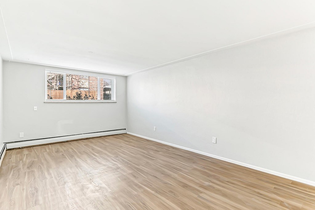 A room with wooden flooring and a picture on the wall.