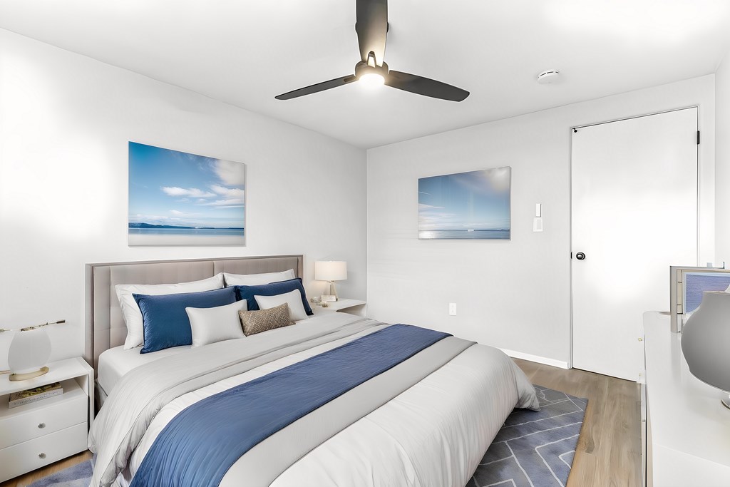 A bedroom with a large bed and a ceiling fan.