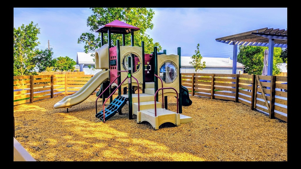 A playground with a slide, a roundabout and a climbing frame.