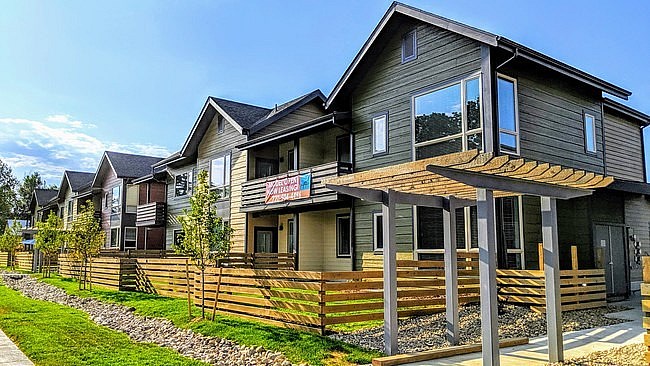 A row of houses with a wooden fence in front.