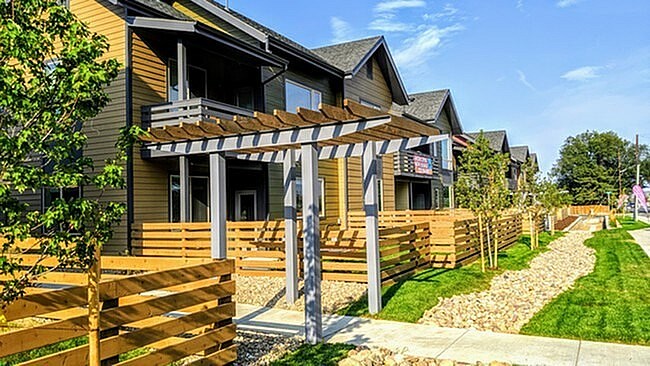 A row of wooden houses with a clear blue sky above.
