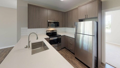 A modern kitchen with a stainless steel refrigerator and a white countertop.
