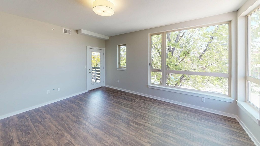 A room with wooden floors and a large window.