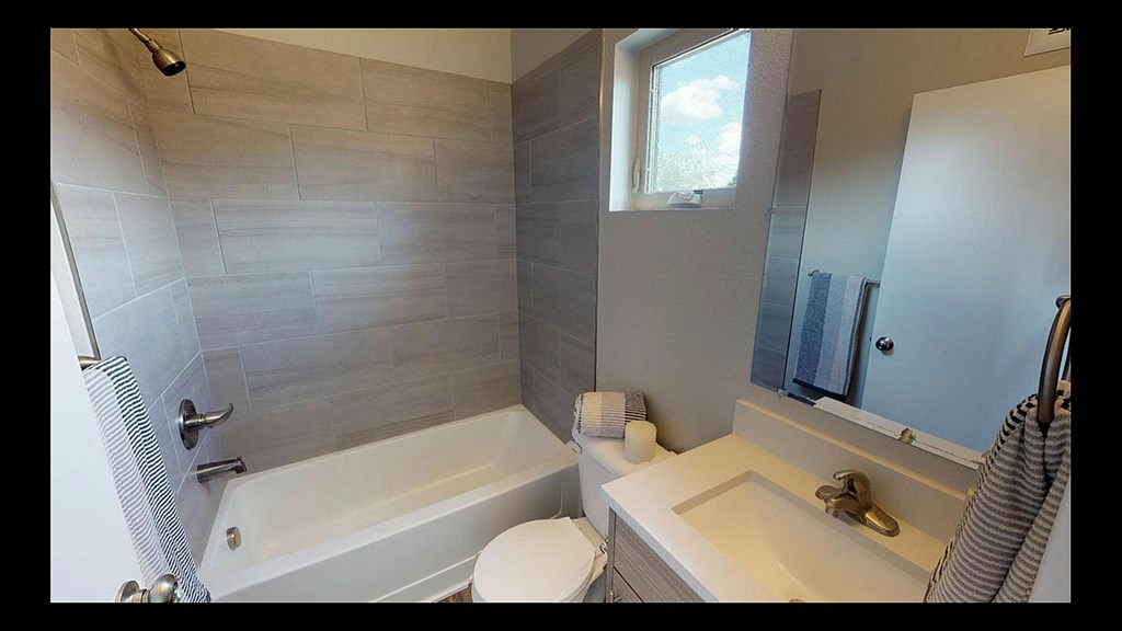 A bathroom with a white tub, toilet, and sink.