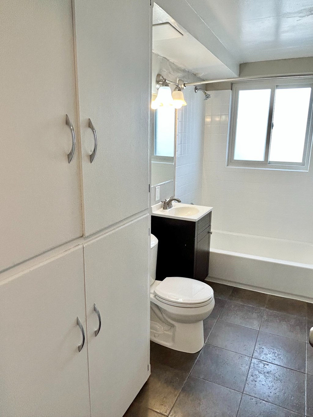 A white toilet is in a bathroom with a white door.