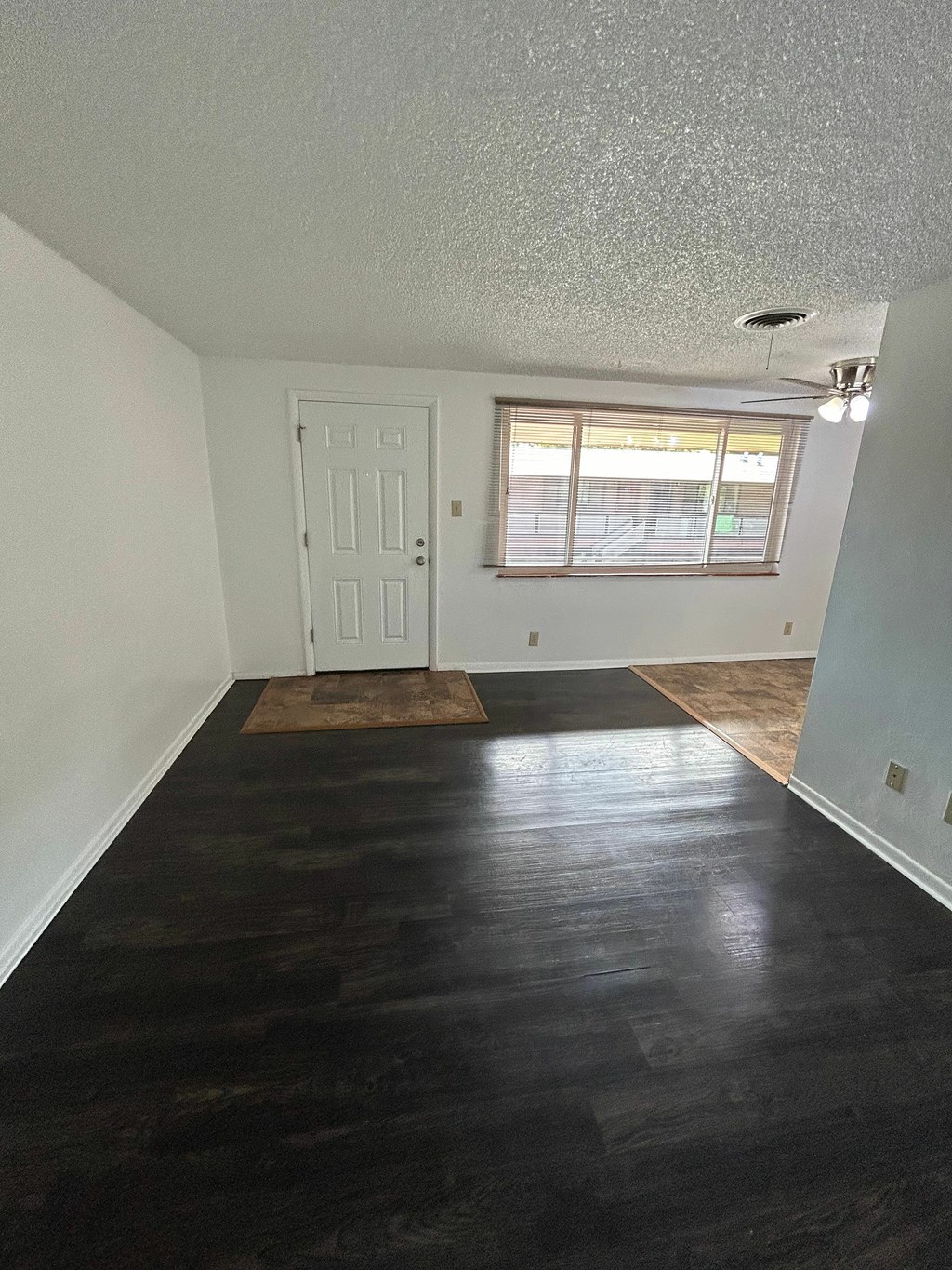 A room with a white door and a window with blinds.