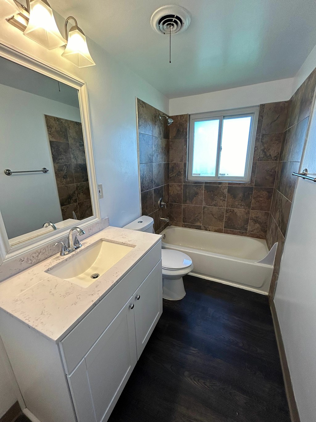 A bathroom with a sink, toilet, and tub.