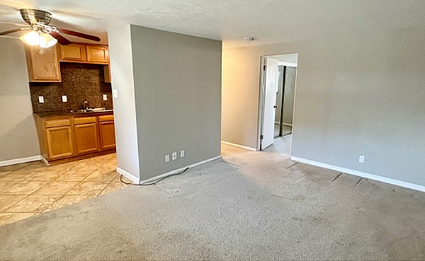 A room with a carpeted floor and a door leading to another room.