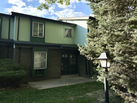 A building with a green and grey exterior and a black lamp post.