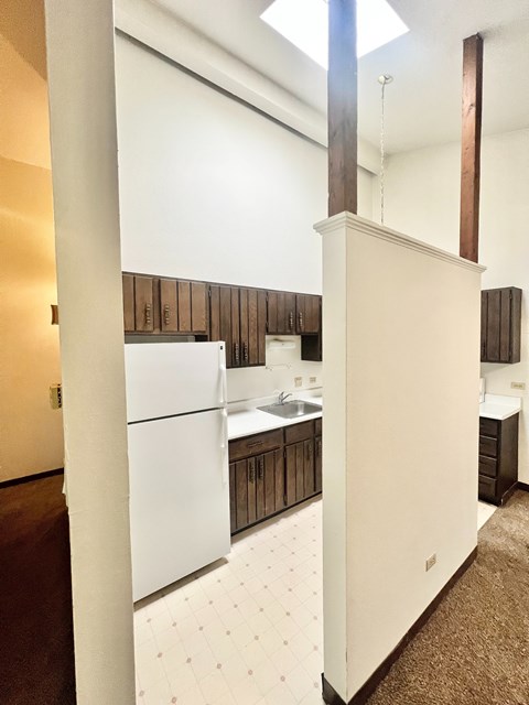 A kitchen with white cabinets and a white fridge.