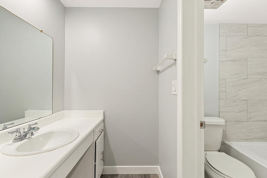 A white bathroom with a sink, toilet, and bathtub.
