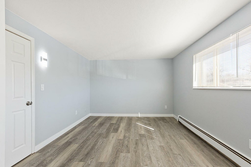 A room with a white door and a window with blinds.