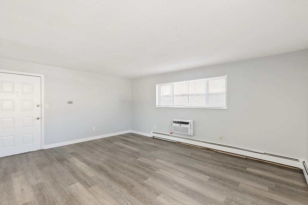 A room with a white door and a window with blinds.