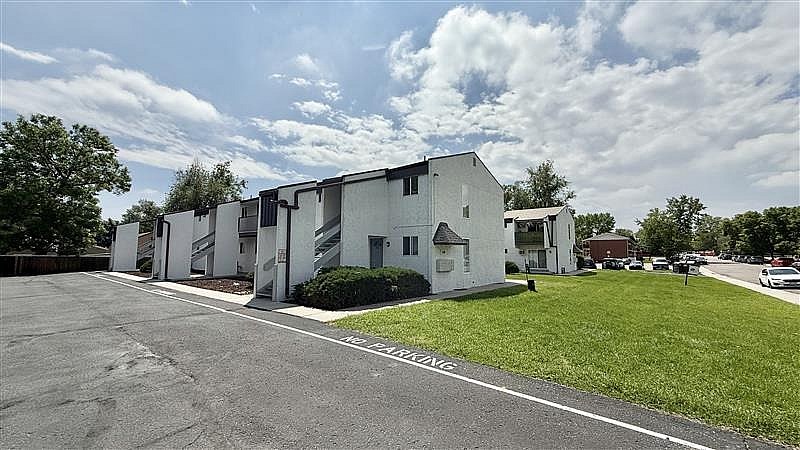 A white building with a green lawn in front.