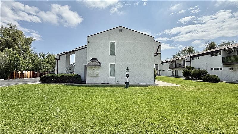 A white building with a black mailbox in front of it.