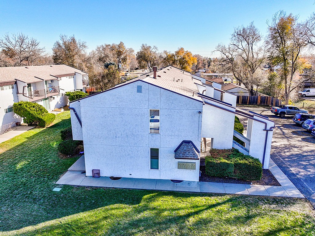 A white house with a grey roof and a small porch.