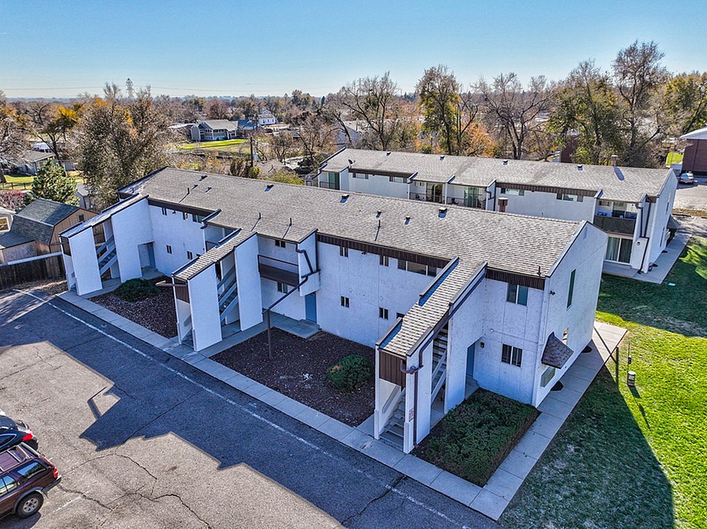 A large white building with a parking lot in front.