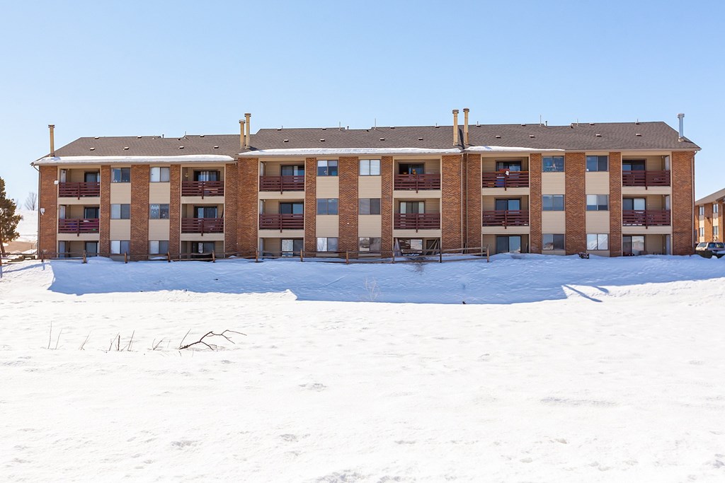 A large building with a lot of windows and balconies covered in snow.