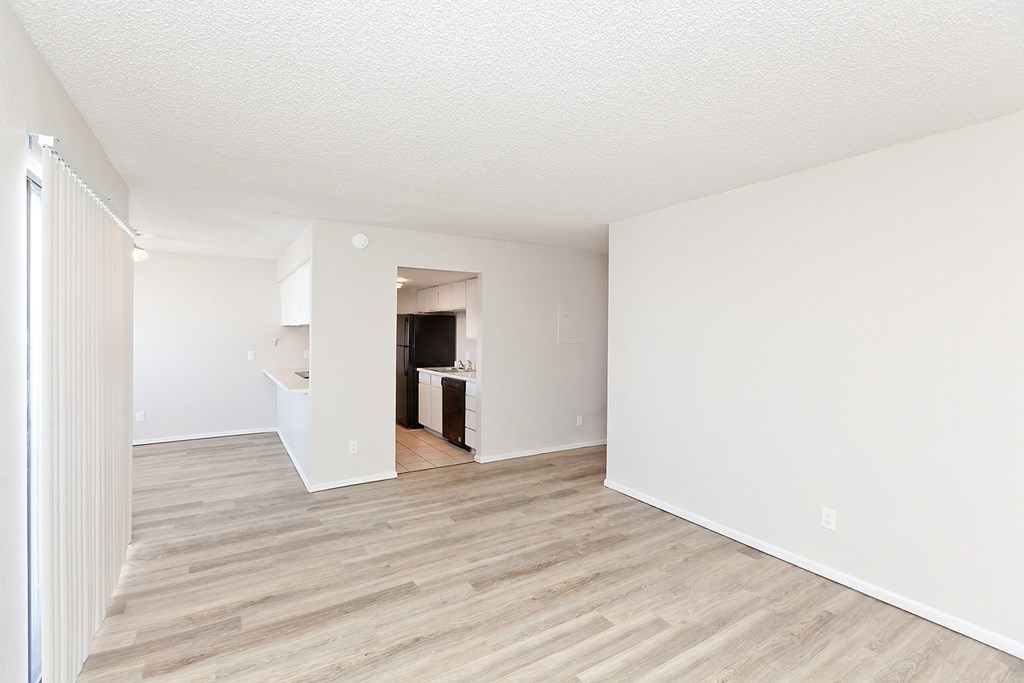 A room with wooden flooring and white walls.