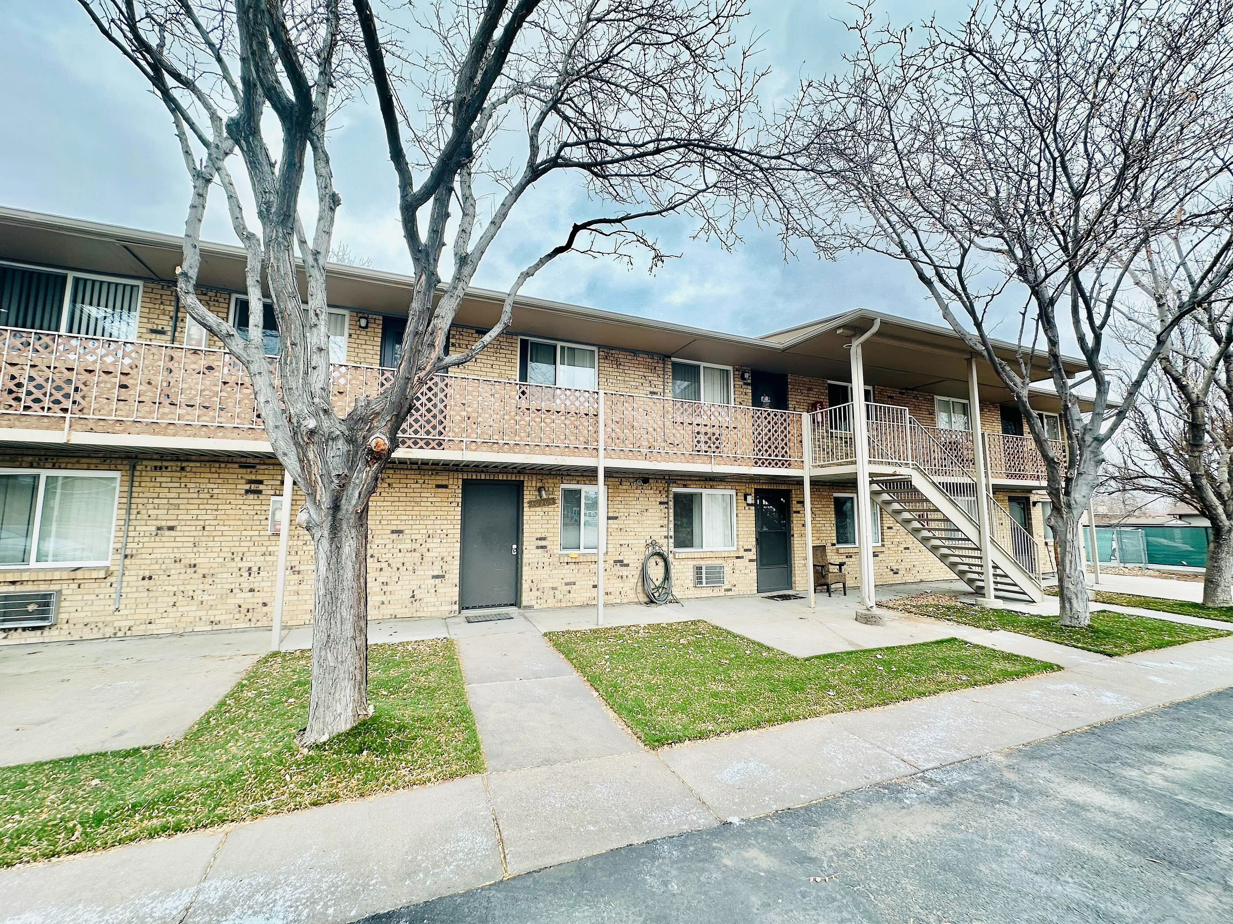 Apartment building with a tree in front.