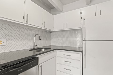 A kitchen with white cabinets and a black stove top oven.