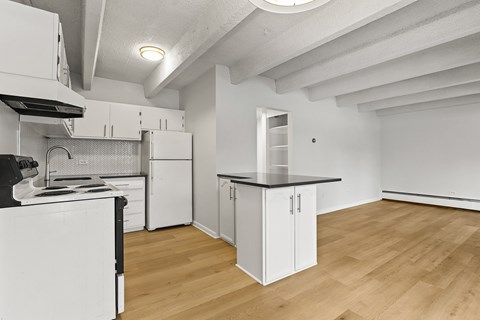 A kitchen with white cabinets and a black stove top oven.